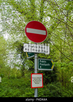 Plusieurs panneaux sur un seul panneau sur un sentier public et une route privée au Royaume-Uni. Banque D'Images