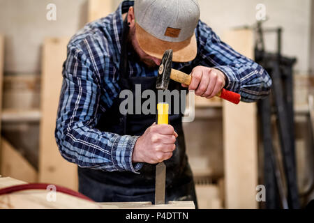 Strong carpenter en bois Sculpture sur les vêtements de travail à l'aide d'un outil à bois, ciseau, mains close up, menuiserie et artisanat concept Banque D'Images