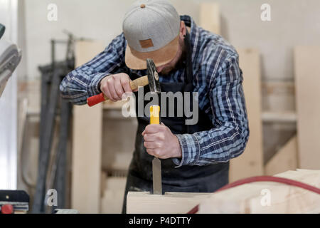 Strong carpenter en bois Sculpture sur les vêtements de travail à l'aide d'un outil à bois, ciseau, mains close up, menuiserie et artisanat concept Banque D'Images