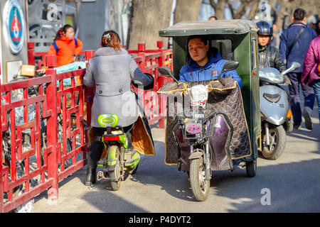 BEIJING, CHINE - le 10 mars 2016 : Les gens de la conduite dans les rues avec des vélos, scooters et voitures. Banque D'Images