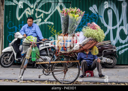 Hanoi, Vietnam - 15 mars 2018 : marchande de fleurs avec un vélo à travailler sur une rue de Hanoi old town Banque D'Images