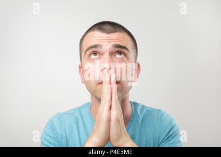 Closeup portrait of desperate young man in blue shirt montrant les mains jointes,demander de l'aide ou une excuse. Les droits de l'expression faciale des émotions, sentiments corps Banque D'Images