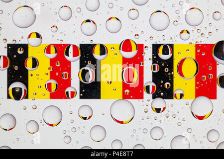 Drapeaux de Belgique derrière un verre recouvert de gouttes de pluie. Banque D'Images