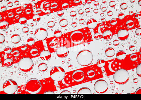 Drapeaux de Singapour, derrière un verre recouvert de gouttes de pluie.motif dans un pavillon de Singapour Banque D'Images