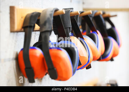 Ligne de cache-oreilles orange protection auditive sur grille. la santé et la sécurité au travail travail sécuritaire. concept de la surdité la pratique. Banque D'Images