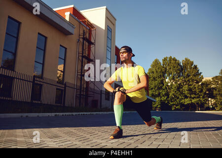 Un gars en sportswear fait un warm-up dans la rue. Banque D'Images