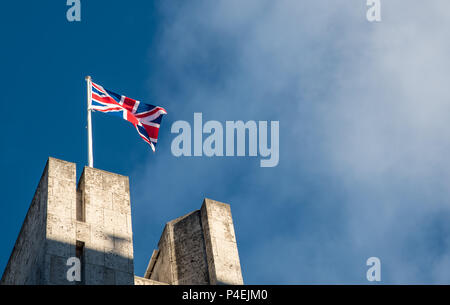 Brandir le drapeau britannique contre un ciel nuageux bleu sur le haut d'un immeuble à Londres UK Banque D'Images