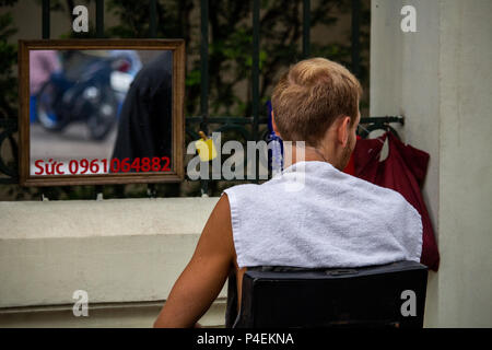 Hanoi, Vietnam - 16 mars 2018 : touristique ayant une coupe par un salon de coiffure de la rue à Hanoi Banque D'Images