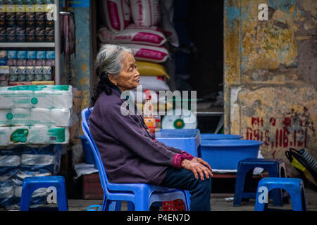 Hanoi, Vietnam - 16 mars 2018 : vietnamienne assis sur la rue en face de sa boutique Banque D'Images