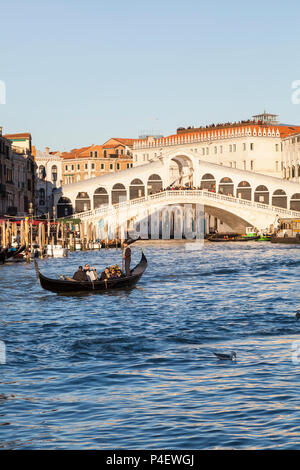 Romantique en gondole sur le Grand Canal au coucher du soleil avec serenade, Pont du Rialto, Venise, Venise, Italie, chanteur et musicien à l'accordéon. La coopération touristique Banque D'Images