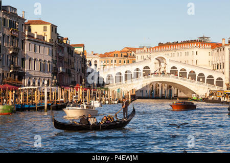 Romantique en gondole sur le Grand Canal au coucher du soleil avec serenade, Pont du Rialto, Venise, Venise, Italie, chanteur et musicien à l'accordéon. La coopération touristique Banque D'Images