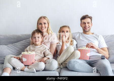 Excitée jeune famille regarder la vidéo sur la table à la maison Banque D'Images