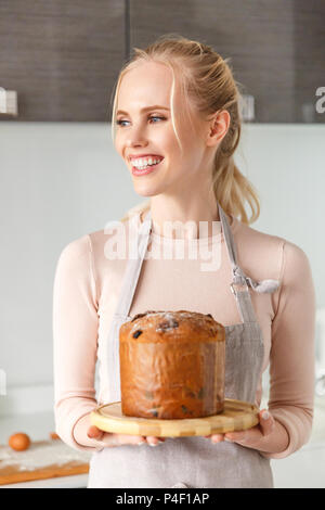 Belle jeune femme en tenue de l'aire frais délicieux gâteau de Pâques à la maison Banque D'Images