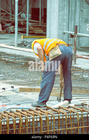 Monteur d'armature travaillant sur coffrage pour béton at construction site. Vintage style. Banque D'Images