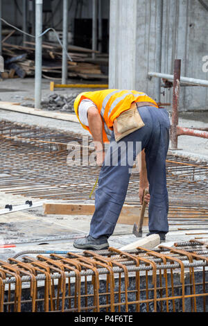 Monteur d'armature travaillant sur coffrage pour béton at construction site. Banque D'Images