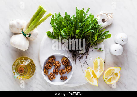 Ingrédients pour faire le pesto de roquette et noix. Sauce méditerranéenne de l'été pour des salades, des pâtes et des collations. L'alimentation saine Banque D'Images