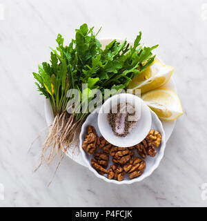 Ingrédients pour faire le pesto de roquette et noix. Sauce méditerranéenne de l'été pour des salades, des pâtes et des collations. L'alimentation saine Banque D'Images