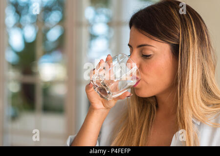 Belle jeune femme de boire un verre d'eau à la maison. Concept de vie. Banque D'Images