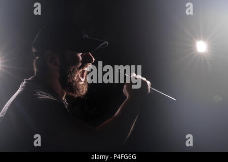 Homme barbu dans un bouchon avec un micro à la main, chante avec une chanteuse sur scène, concept image tonique Banque D'Images