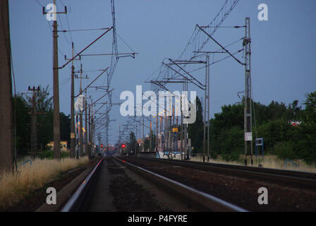 Les voies de chemin de fer sur le crépuscule. Les voies et les trains d'approvisionnement électrique. Banque D'Images