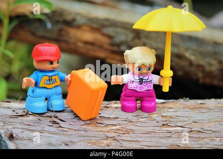 Duplo garçon et fille de caractères avec parasol et serviette contre un arrière-plan flou - News Concept Banque D'Images