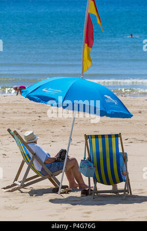 Bournemouth, Dorset, UK. 22 juin 2018. Météo France : belle chaude journée ensoleillée à plages de Bournemouth en tant que visiteurs, chef de la station pour profiter du soleil, comme la prévision est pour les températures d'augmenter. En quelques transats sous parasol sur la plage. Credit : Carolyn Jenkins/Alamy Live News Banque D'Images