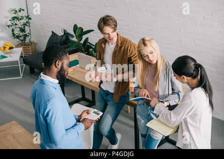Portrait de collègues d'affaires multiethniques avec les manuels scolaires, d'une calculatrice et une réunion ayant Banque D'Images