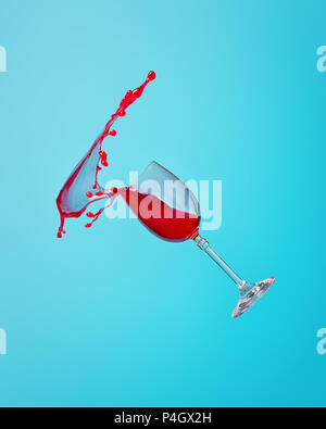 Abstract splash de vin rouge dans un verre sur un fond bleu de près. Banque D'Images