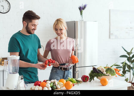 Couple de végétaliens comment choisir les légumes pour la salade à la cuisine Banque D'Images