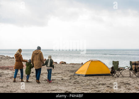 Jeune famille holding hands à tente sur mer Banque D'Images