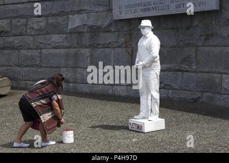 Femme touristiques laissant astuce pour Plasterman, célèbre artiste de rue à Victoria (C.-B.), le centre-ville de Harbour sur l'île de Vancouver Banque D'Images