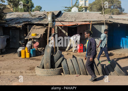 Addis Abeba, Ethiopie, le 30 janvier 2014, le vendeur de pneus sur une rue animée avec divers commerces informels dans l'arrière-plan Banque D'Images