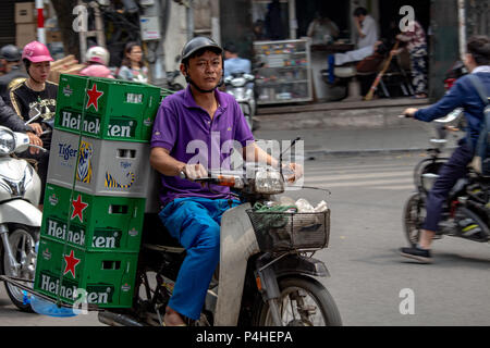 Hanoi, Vietnam - Mars 16, 2018 : l'homme local de transporter des charges de bières sur une moto Banque D'Images