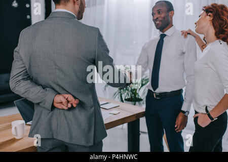 Businessman with fingers crossed main tremblante au partenaire Banque D'Images