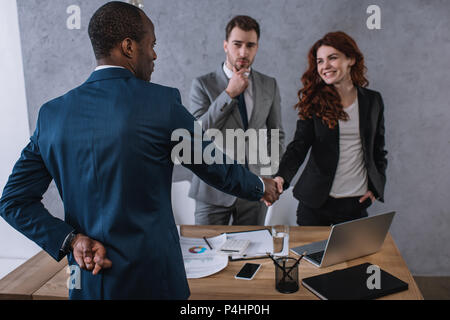 Businessman with fingers crossed main tremblante au partenaire Banque D'Images