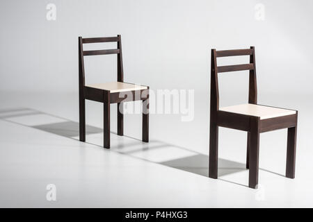 Deux chaises en bois sombre classique avec du blanc haut standing in row sur marbre blanc en studio Banque D'Images