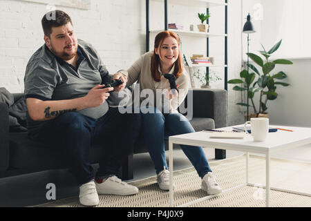 Copain copine et heureux de jouer à la maison de jeux vidéo Banque D'Images
