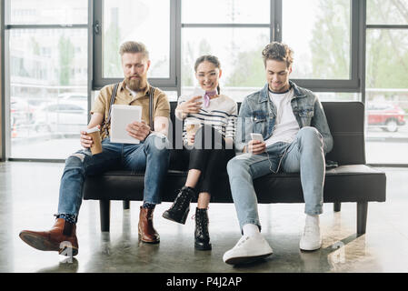 Des gens d'affaires qui ont réussi à l'aide de gadgets sur le bureau d'éclairage moderne Banque D'Images