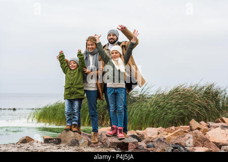 Heureux jeune famille avec les mains posées sur mer Banque D'Images