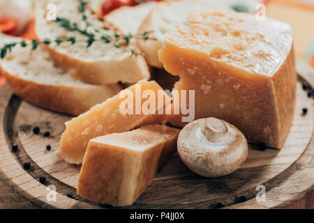 Close-up view of delicious la baguette et le fromage parmesan avec champignon sur planche à découper en bois Banque D'Images