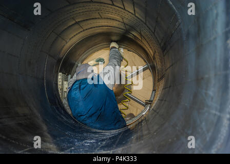 Un volontaire travaillant sur le moteur d'un ancien bombardier nucléaire Avro Vulcan B2 préservé de RAF Cold War. Tunnel d'admission. Corrosion par projection de grenaille. Man. Homme Banque D'Images