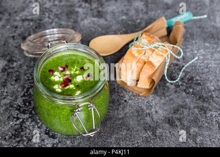 Soupe au chou vert dans un bocal en verre avec graines de grenade et de cubes de feta Banque D'Images