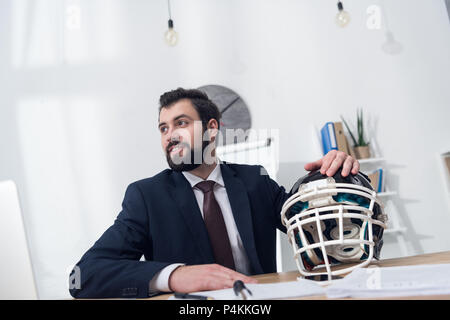 Young businessman with rugby casque en vert au travail Banque D'Images