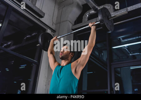 Strong sportsman barbell levage pendant l'entraînement en salle de sport Banque D'Images