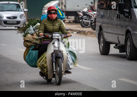 Hanoi, Vietnam - 16 mars 2018 : femme transportant une lourde charge de bagages sur sa moto Banque D'Images