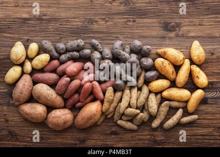 Un assortiment de types de pomme de terre sur une surface en bois Banque D'Images