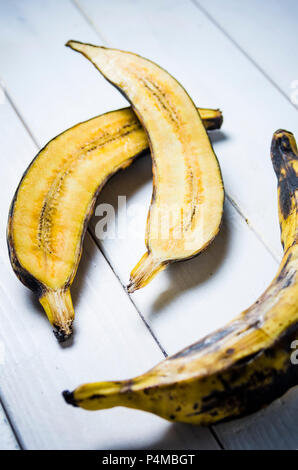 La banane plantain coupée en deux et ensemble on a white background Banque D'Images