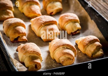 Des croissants fraîchement cuits sur une plaque de cuisson Banque D'Images