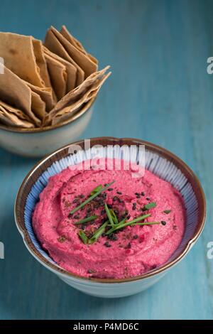 Houmous de betterave rouge servi avec craquelins pita Banque D'Images