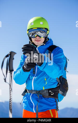 Photo de l'homme d'en casque et lunettes avec bâtons de ski sur journée d'hiver Banque D'Images